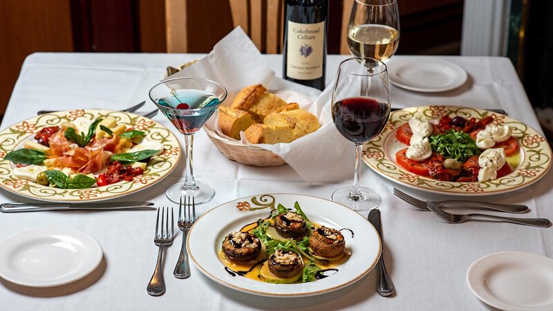 Multiple plated appetizers with focus on stuffed mushrooms